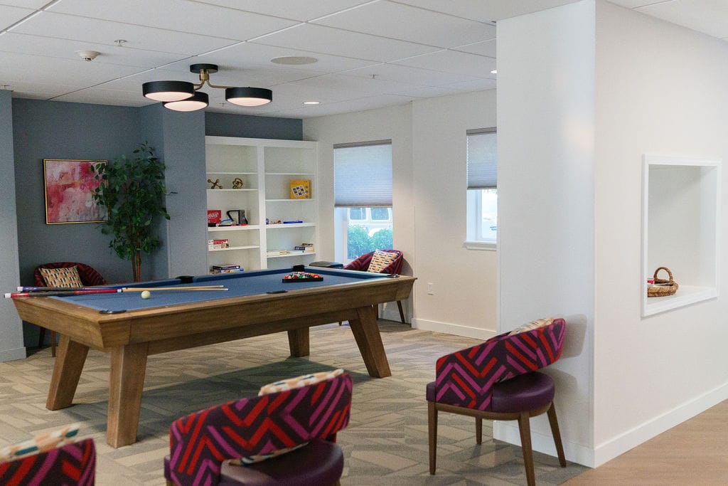 Billiards room at McLoughlin Place with a pool table and bookshelves along the wall
